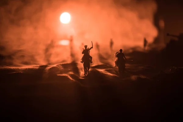 Officier de guerre mondial (ou guerrier) cavalier à cheval avec une épée prête à se battre et des soldats sur un fond sombre et brumeux. Scène de bataille champ de bataille des soldats de combat . — Photo