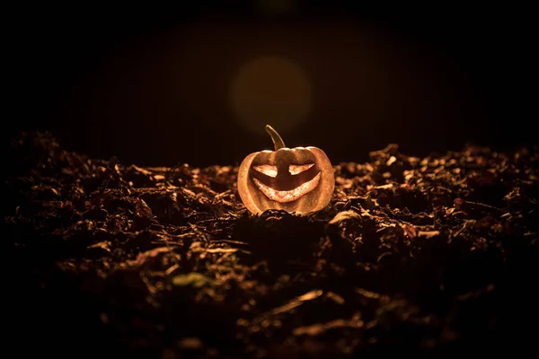 Halloween jack-o-linterna en hojas de otoño. Calabaza de Halloween asustadiza mirando a través del humo. Brillante , —  Fotos de Stock