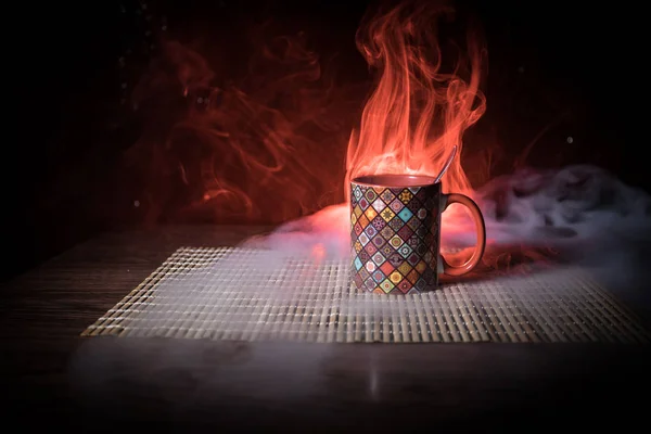 Hermosa taza de cerámica texturizada de estilo oriental de café (o té) con humo sobre fondo tonificado oscuro . —  Fotos de Stock