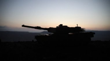 Savaş Konsepti. Savaş sis gökyüzü arka plan üzerinde sahne mücadele Askeri siluetler, Gece Bulutlu Skyline Altında Dünya Savaşı Alman Tankları Siluetler. Saldırı sahnesi. Zırhlı araçlar ve piyadeler.
