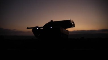 Savaş Konsepti. Savaş sis gökyüzü arka plan üzerinde sahne mücadele Askeri siluetler, Gece Bulutlu Skyline Altında Dünya Savaşı Alman Tankları Siluetler. Saldırı sahnesi. Zırhlı araçlar ve piyadeler.
