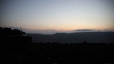 Savaş Konsepti. Savaş sis gökyüzü arka plan üzerinde sahne mücadele Askeri siluetler, Gece Bulutlu Skyline Altında Dünya Savaşı Alman Tankları Siluetler. Saldırı sahnesi. Zırhlı araçlar ve piyadeler.