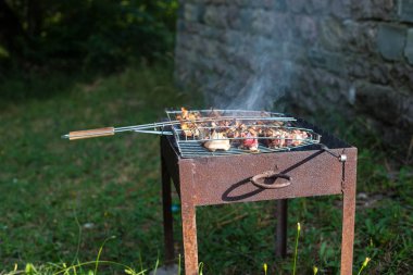 Metal şişte pişen ızgara kebap. Barbeküde kızartılmış et. Geleneksel doğu yemeği, şiş kebap. Kömür ve alevler üzerine ızgara, piknik, sokak yemekleri