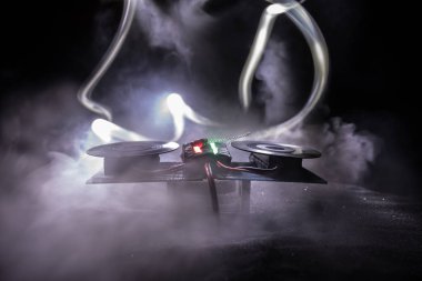 DJ kulübü konsepti. Işıklar ve sis ile koyu tonlu arkaplan üzerine DJ tablosunun yaratıcı sanat dekorasyonu.