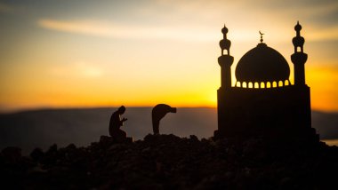 Din Kavramı İslam. Gün batımında caminin arka planında dua eden adamın silueti