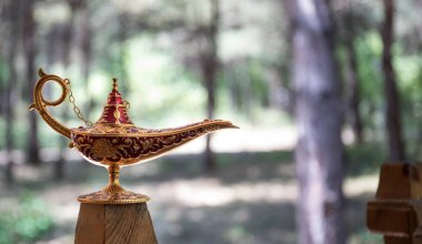 Antique artisanal Aladdin Arabian nights genie style oil lamp at the forest. Lamp of wishes fantasy concept clipart