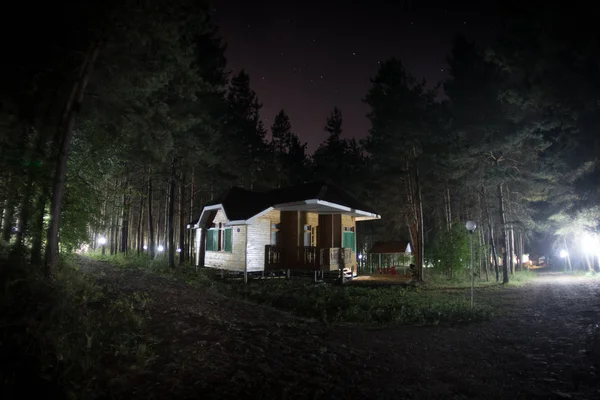 Old house with a Ghost in the forest at night or Abandoned Haunted Horror House in fog. Old mystic building in dead tree forest. Trees at night with moon. Surreal lights. Horror Halloween concept — Stock Photo, Image