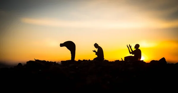 Concept of religion Islam. Silhouette of man praying on the background of a mosque at sunset — Stock Photo, Image