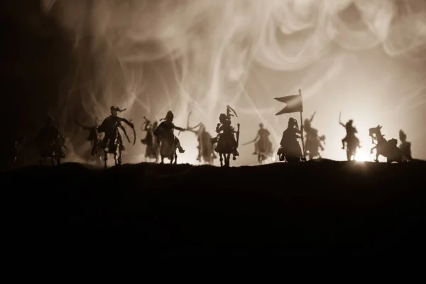 Cena de batalha medieval com cavalaria e infantaria. Silhuetas de figuras como objetos separados, luta entre guerreiros em fundo enevoado escuro. Cena noturna . — Fotografia de Stock