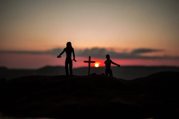 Silhueta alguns zumbis no cemitério andando ao pôr-do-sol. Foco seletivo — Fotografia de Stock