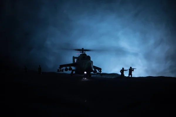 Silhouette of military helicopter ready to fly from conflict zone. Decorated night footage with helicopter starting in desert with foggy toned backlit. Selective focus. — Stock Photo, Image