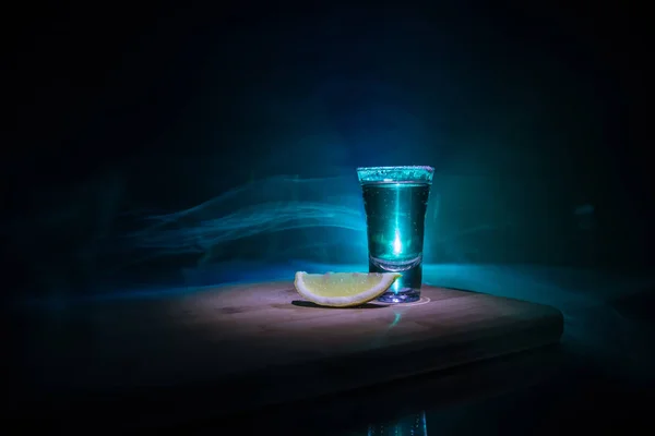 Concetto da club drink. Gustoso cocktail di bevande alcoliche tequila con lime e sale su uno sfondo scuro vibrante o bicchieri con tequila in un bar — Foto Stock