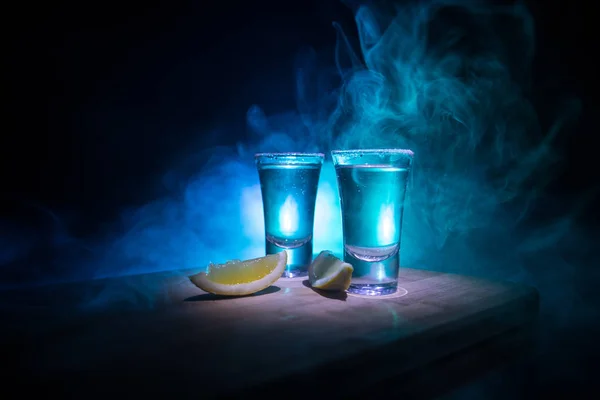 Conceito de bebida do clube. Bebida de álcool saborosa coquetel tequila com limão e sal em fundo escuro vibrante ou óculos com tequila em um bar — Fotografia de Stock