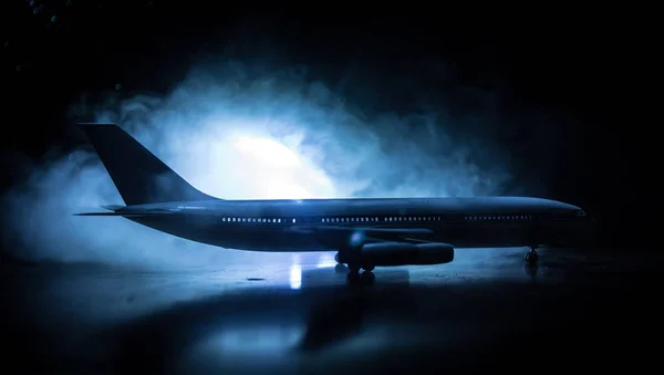 Decoración de obra. Avión de pasajeros blanco listo para despegar de la pista del aeropuerto. Silueta de aviones durante la noche . —  Fotos de Stock