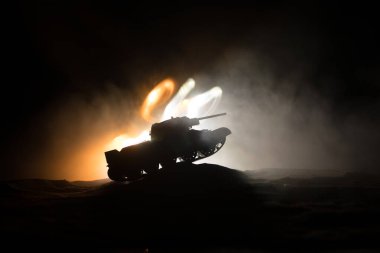 Savaş Konsepti. Askeri siluetler savaş sis gökyüzü arka plan üzerinde sahne mücadele, Geceleri Cloudy Skyline altında zırhlı araç Siluet. Saldırı sahnesi. Tanklar savaşı.