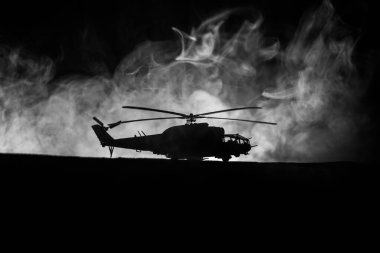 Askeri helikopter çatışma bölgesinden uçmaya hazır silüeti. Gece görüntüleri çöl sisli tonda sırt ile başlayarak helikopter ile dekore edilmiştir. Seçici odak.