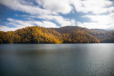 Göl ve dağlarla sakin bir akşam manzarası. Ganja, Azerbaycan 'daki renkli sonbahar ormanları arasında Goy-Gol Gölü' nün (Mavi Göl) inanılmaz manzarası.