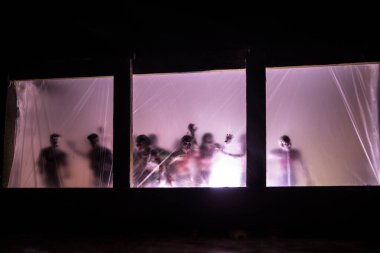 Geceleri ormanda hayaletli eski bir ev. Pencerede korku silueti. Ormandaki eski bina. Gerçeküstü ışıklar. Korku Halloween kavramı