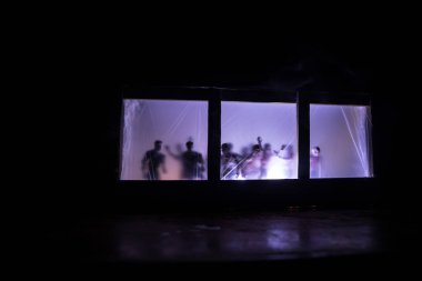 Geceleri ormanda hayaletli eski bir ev. Pencerede korku silueti. Ormandaki eski bina. Gerçeküstü ışıklar. Korku Halloween kavramı