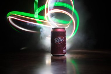 Bakü, Azerbaycan - 15 Eylül 2019: Koyu tonlu sisli arka planda ışıkla birlikte Dr Pepper'ın meşrubata bakması. Dr Pepper eşsiz bir lezzete sahip olarak pazarlanan bir meşrubat.