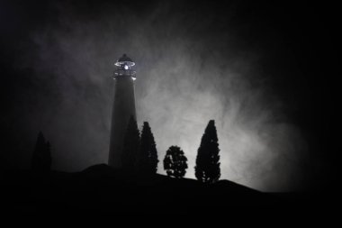 Sis ile gece ışık demeti ile deniz feneri. Eski feneri ayakta Dağı'nda. Masa dekorasyonu. Tonlu arka plan. Ek iş.