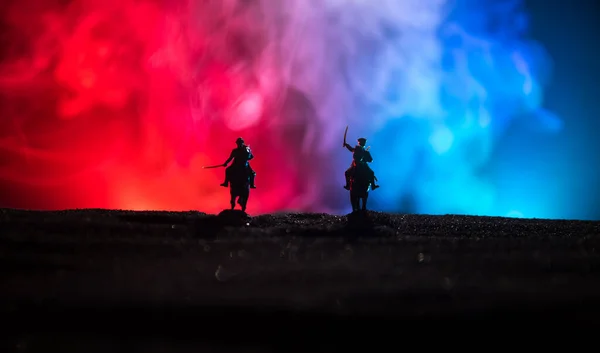 Oficial de la guerra mundial (o guerrero) jinete a caballo con una espada lista para luchar y soldados sobre un fondo oscuro brumoso tonificado. Campo de batalla de la escena de batalla de soldados de combate . —  Fotos de Stock