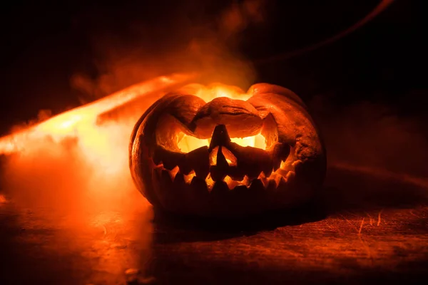 Vista de perto da abóbora de Halloween assustadora com olhos brilhando dentro no fundo preto. Foco seletivo — Fotografia de Stock