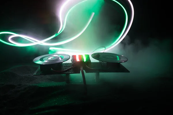 Koncept DJ klubu. Tvůrčí umělecká výzdoba stolu DJ na tmavém tónovaném pozadí se světly a mlhou. — Stock fotografie