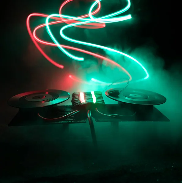 Conceito de clube de DJ. Decoração de arte criativa da tabela dj no fundo tonificado escuro com luzes e nevoeiro . — Fotografia de Stock