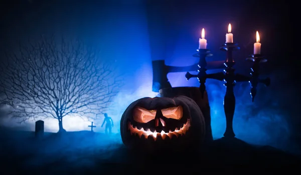 Scary view of zombies at cemetery at night. Dead tree and spooky cloudy sky with fog. Horror Halloween concept with glowing pumpkin. — Stock Photo, Image