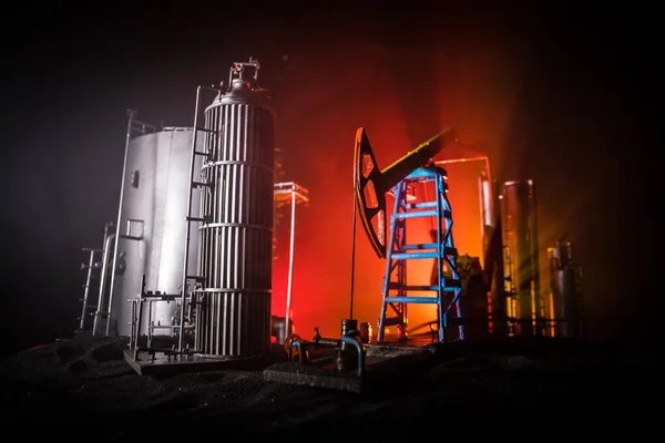 Decoración de obra. Bomba de aceite y plataforma de aceite máquinas industriales de energía para el petróleo por la noche con niebla y contraluz. Fábrica de refino de petróleo. Concepto industrial energético. Enfoque selectivo — Foto de Stock