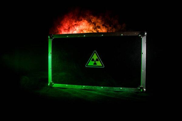 Man in gas mask and cloak for chemical protection on abandoned road with radiation area caution sing under heavy clouds. Nature protection concept