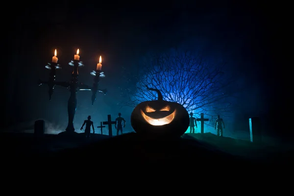 Scary view of zombies at cemetery at night. Dead tree and spooky cloudy sky with fog. Horror Halloween concept with glowing pumpkin. — Stock Photo, Image