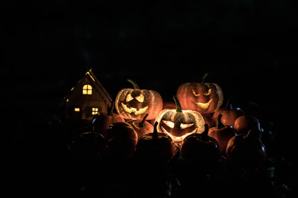 Halloween jack-o-lantern on autumn leaves. Scary Halloween Pumpkin looking through the smoke. Glowing, — Stock Photo, Image