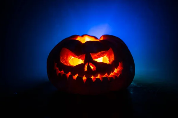 Vista da vicino della spaventosa zucca di Halloween con gli occhi che brillano all'interno su sfondo nero. Focus selettivo — Foto Stock