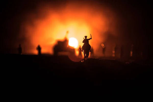 Oficial de guerra mundial (ou guerreiro) cavaleiro a cavalo com uma espada pronta para lutar e soldados em um fundo enevoado escuro. Batalha campo de batalha cena de soldados de combate . — Fotografia de Stock