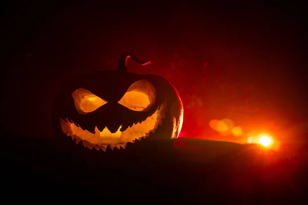 Halloween pumpkin smile and scary eyes for party night. Close up view of scary Halloween pumpkin with eyes glowing inside at black background. — Stock Photo, Image