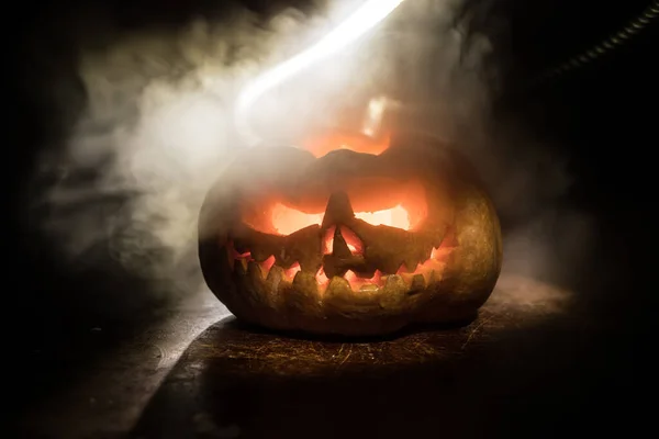 Vista de perto da abóbora de Halloween assustadora com olhos brilhando dentro no fundo preto. Foco seletivo — Fotografia de Stock