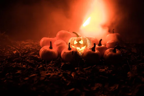 Halloween Jack-o-Laterne auf Herbstblättern. Gruseliger Halloween-Kürbis schaut durch den Rauch. glühend, — Stockfoto