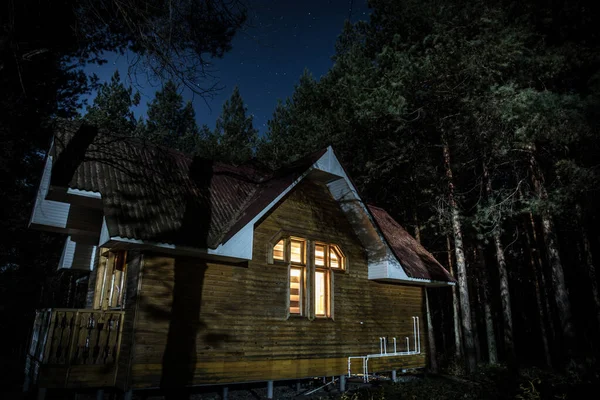 Old spooky house at the pine forest at night. Horror Halloween concept — Stock Photo, Image
