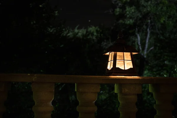 Retro style lantern at night. Beautiful colorful illuminated lamp at the balcony in the garden. — Stock Photo, Image