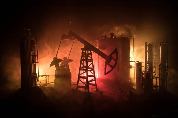 Kunstwerk decoratie. Oliepomp en olieplatform energie industriële machines voor aardolie 's nachts met mist en achtergrondverlichting. Olie raffinaderij. Energie-industrieel concept. Selectieve focus — Stockfoto