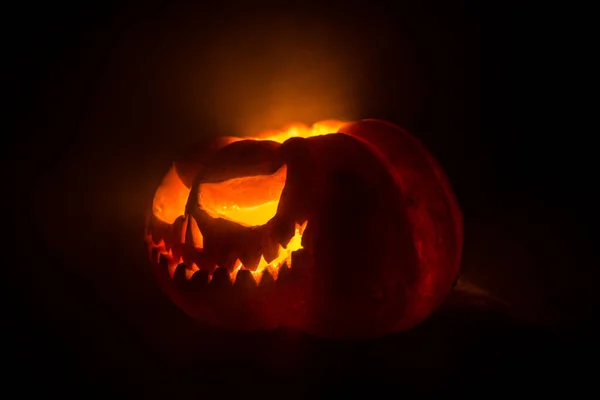 Närbild av skrämmande Halloween pumpa med ögon glöder inuti på svart bakgrund. Selektiv inriktning — Stockfoto