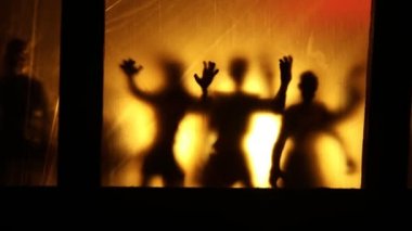 Sanat dekorasyonu. İçinde büyük pencereler ve zombiler olan eski bir ev. Penceredeki bulanık korkunç siluetler. Korku Cadılar Bayramı konsepti