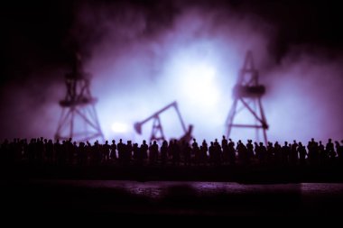 Petrol endüstrisi krizi konsepti. Covid küresel salgını yüzünden petrol borsası krizi. Petrol pompası ve petrol rafineri fabrikası geceleri sis ve arka planda. Yaratıcı sanat dekorasyonu. Seçici odak.