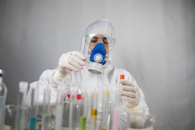 Coronavirus covid 19 elinde cerrahi maskeli ve parlayan bir kadın doktorun enfekte olmuş kan tüpü. Coronavirus covid 19 tedavi laboratuvarı, Coronavirus covid-19 aşı araştırması. Seçici odak