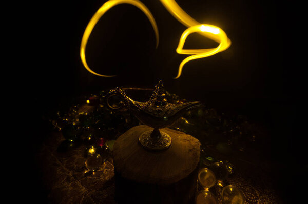 Antique Aladdin arabian nights genie style oil lamp with soft light white smoke, Dark background. Lamp of wishes concept