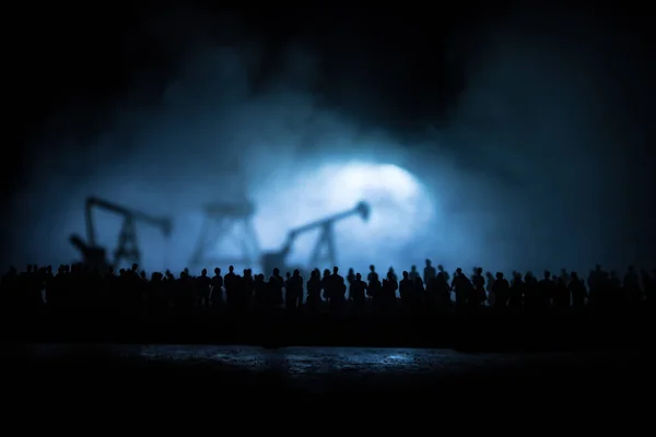 Oil industry crisis concept. Oil stock crisis because Covid global pandemic. Oil pump and oil refining factory at night with fog and backlight. Creative artwork decoration. Selective focus.