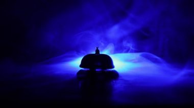 Masanın üstündeki servis çanının karanlık arkaplandaki yakın çekim görüntüleri.