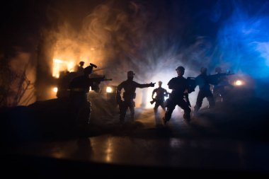 Savaş Konsepti. Savaş sahnesi sisli gökyüzü arka planında geceleri Bulutlu Skyline 'ın altında siluetlerle savaşmak. Askerlerin sanat eserleriyle donatılmış askeri araç. Seçici odak